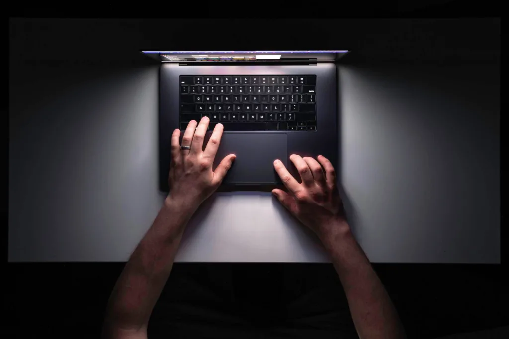 mãos de um usuário de laptop digitando no teclado.