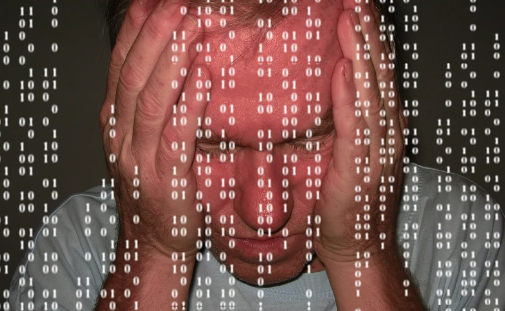 um  homem apoiando a cabeça com as duas mãos em sinal de desespero e números caindo na tela em primeiro plano.