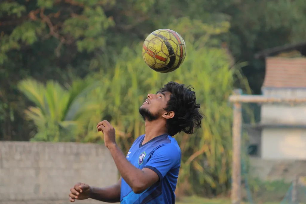 um jogador de futebol fazendo exercícios com a cabeça.