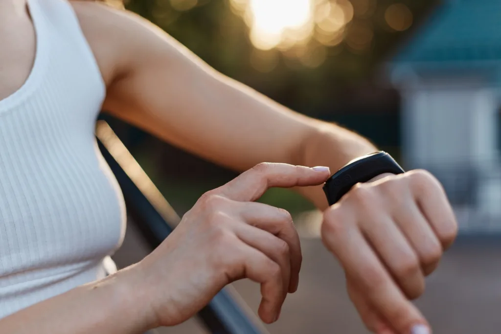 uma jovem ajustando os parâmetros do seu smartwatch.