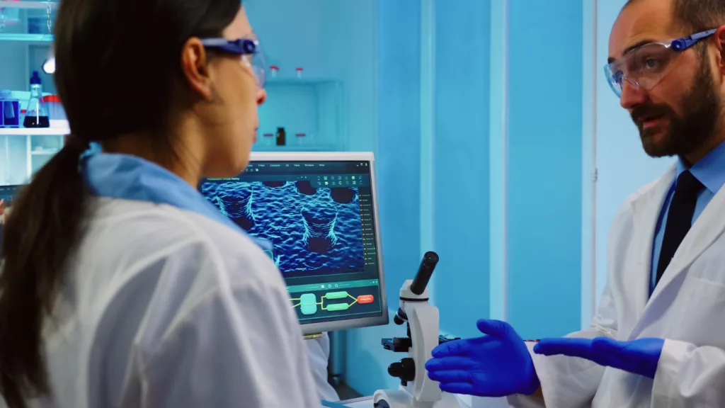 cientistas estudando imagem geradas em um microscópio.