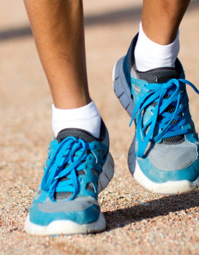 Pés de um atleta calçado com tênis de corrida.
