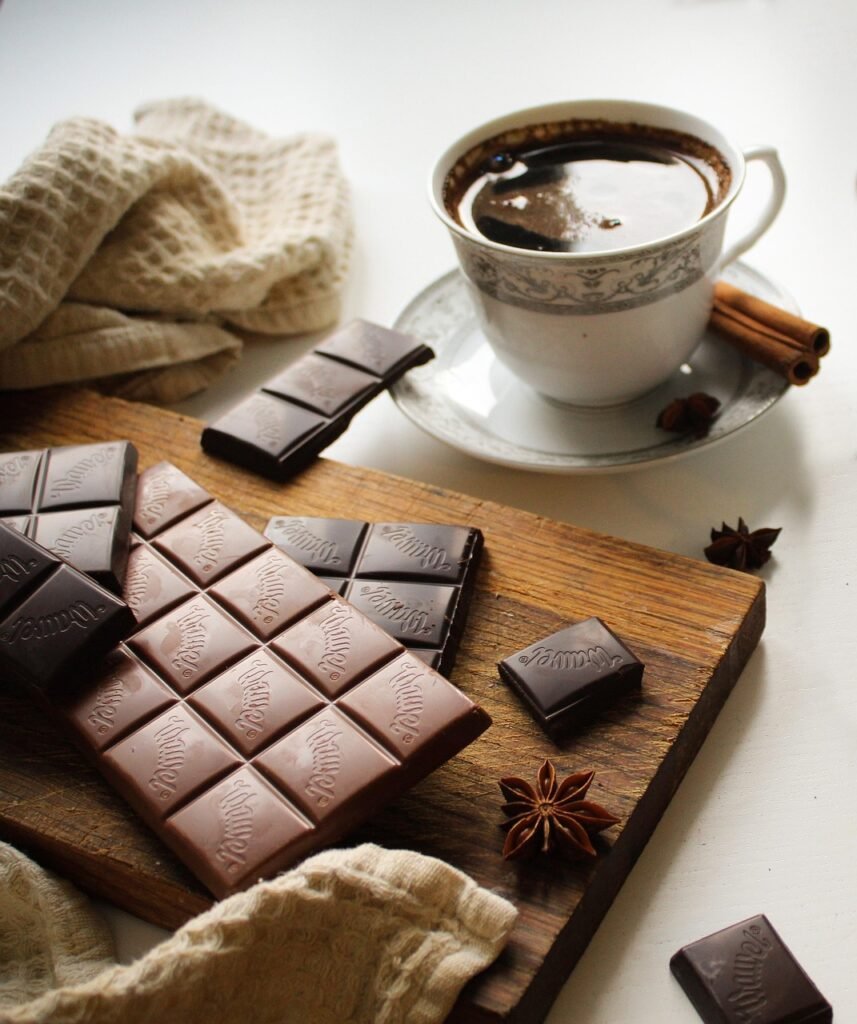xicara de café  com varios tabletes de chocolate amargo.