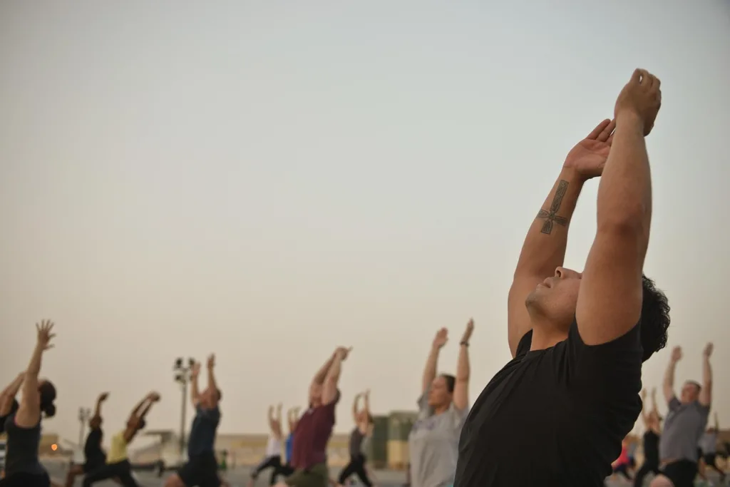 grupo de praticantes  de yoga ao ar livre  no fim de tarde.