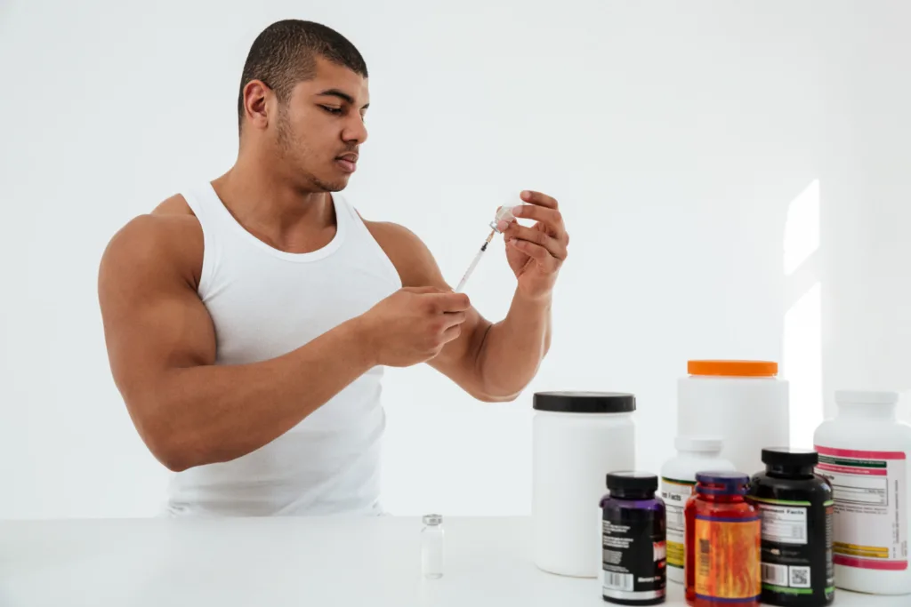 atleta com suplementos e uma seringa nas mãos.