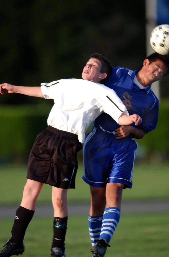 disputa de bola durante uma partida de futebol.