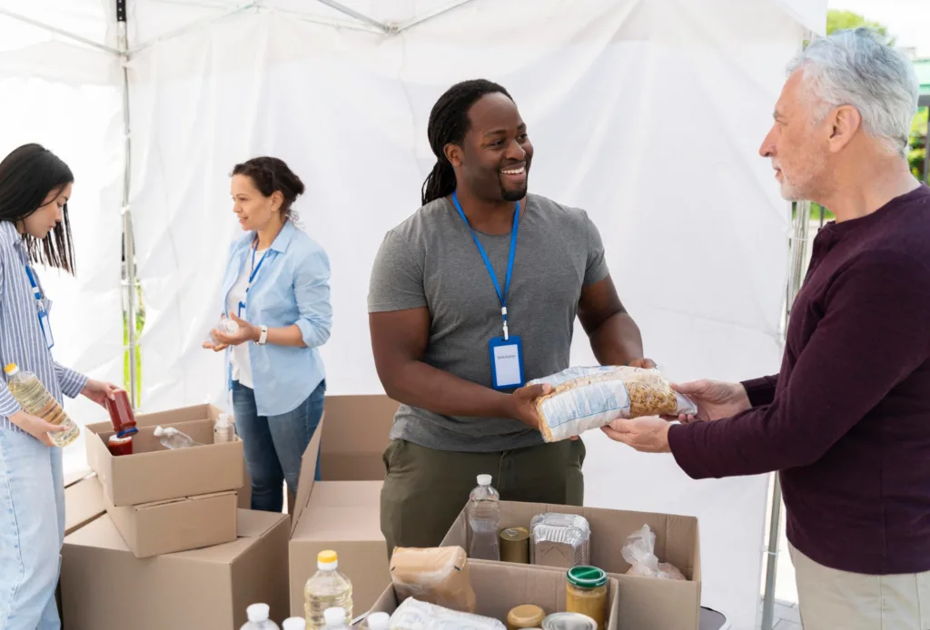 pessoas engajadas em servicos voluntarios de distribuicao de alimentos.