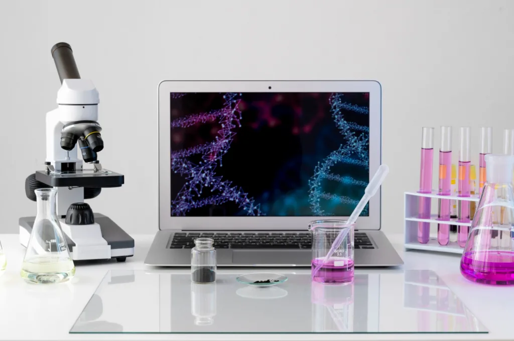 imagem de alguns equipamentos de laboratorio como microscópio, computador e frascos de regentes.