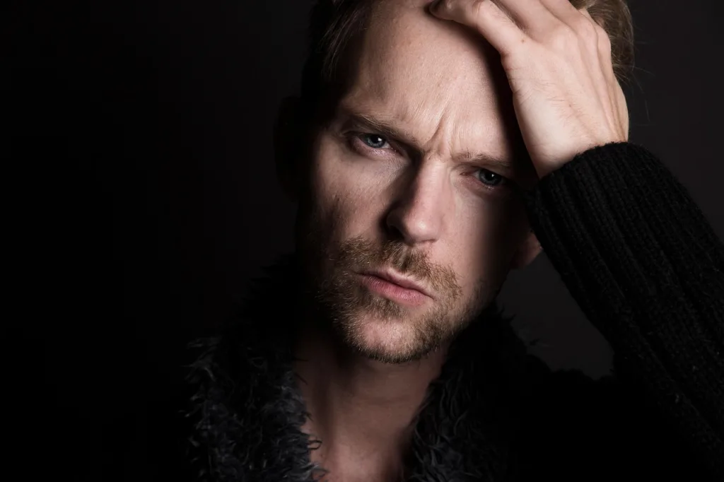 close de um homem triste apoiando sua mão na testa.