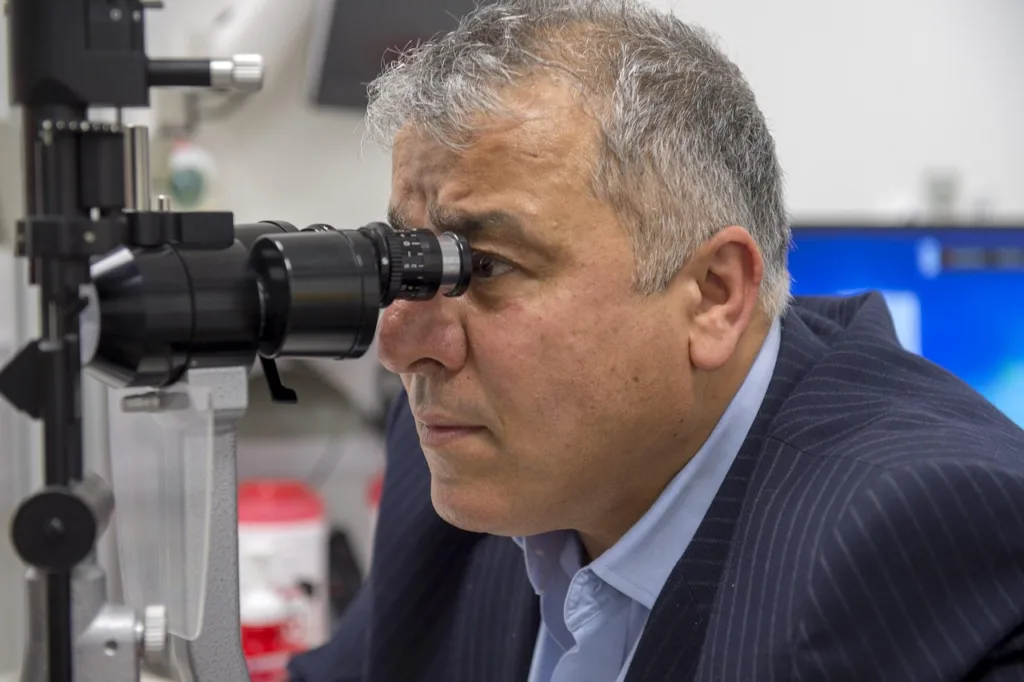 medico analisando os olhos através de um auto refrator.