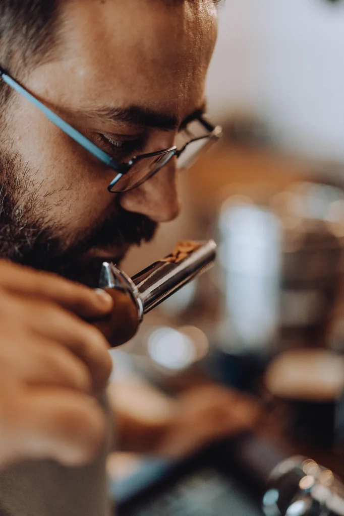 um jovem cheirando amostras de café.