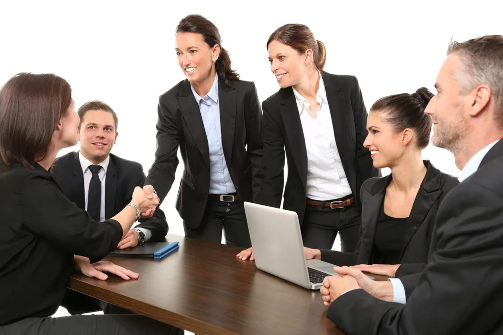 jovens executivos reunidos em uma mesa, se cumprimentando.