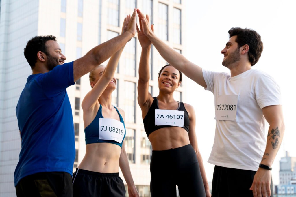 quatro atletas comemorando com o toque das palmas das mãos.
