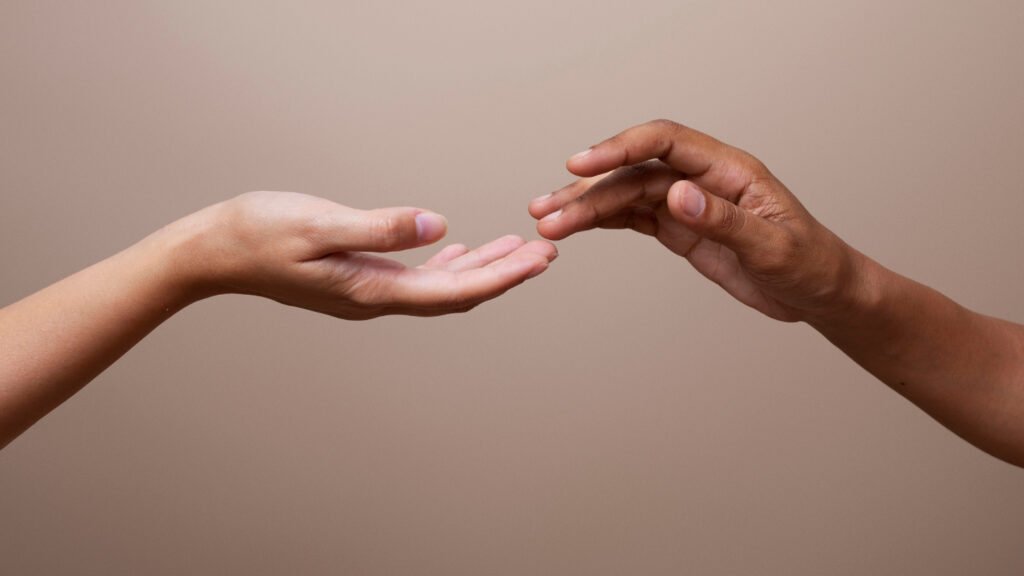 duas mãos se tocando om as pontas dos dedos.
