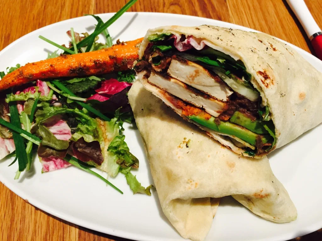 prato de comidas veganas com um wrap de vegetais.