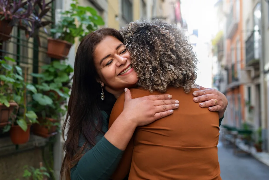 duas amigas se abraçando na rua.