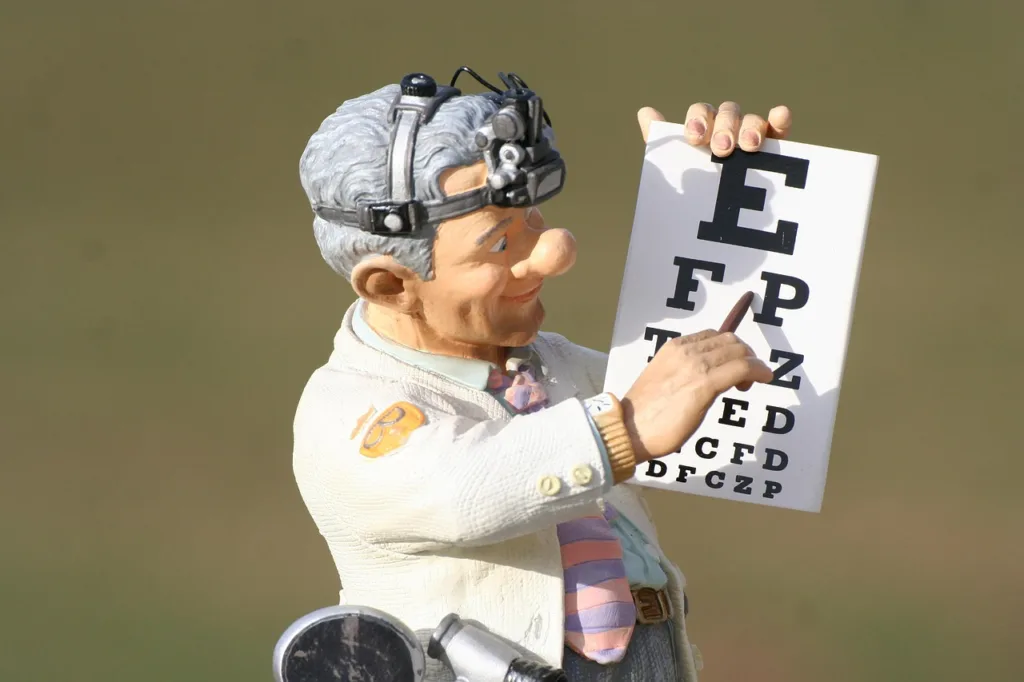 uma pequena estatua de um oftalmologista apontando para uma tabela de letras.