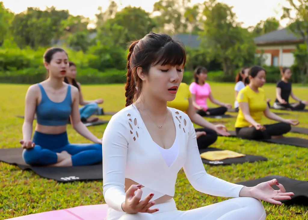 grupo de mulheres praticando yoga ao ar livre.
