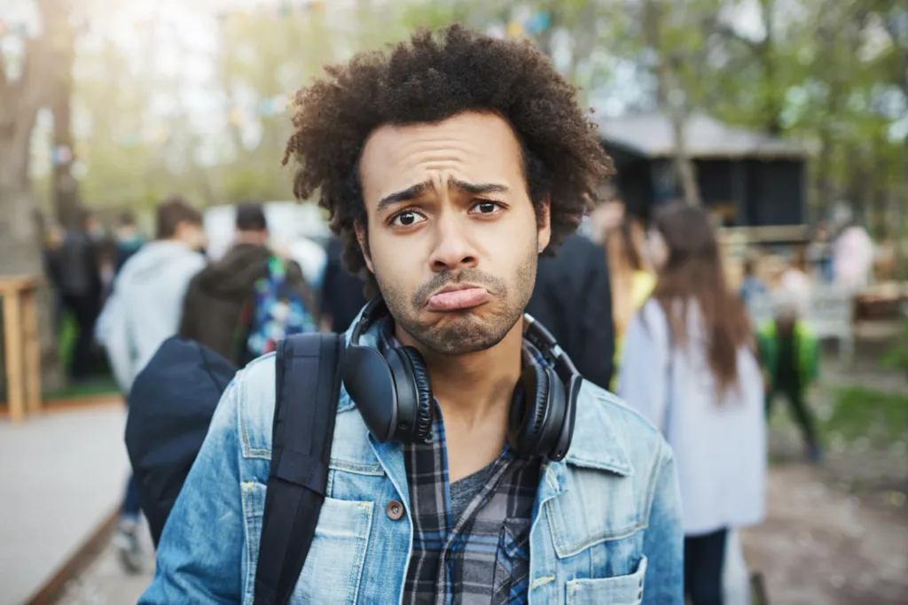 homem afrodescendente com semblante deprimido.  
