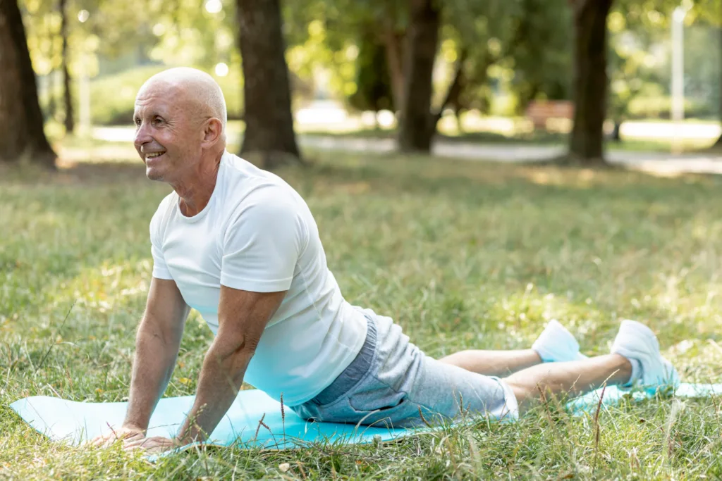 idoso praticando yoga em um parque.