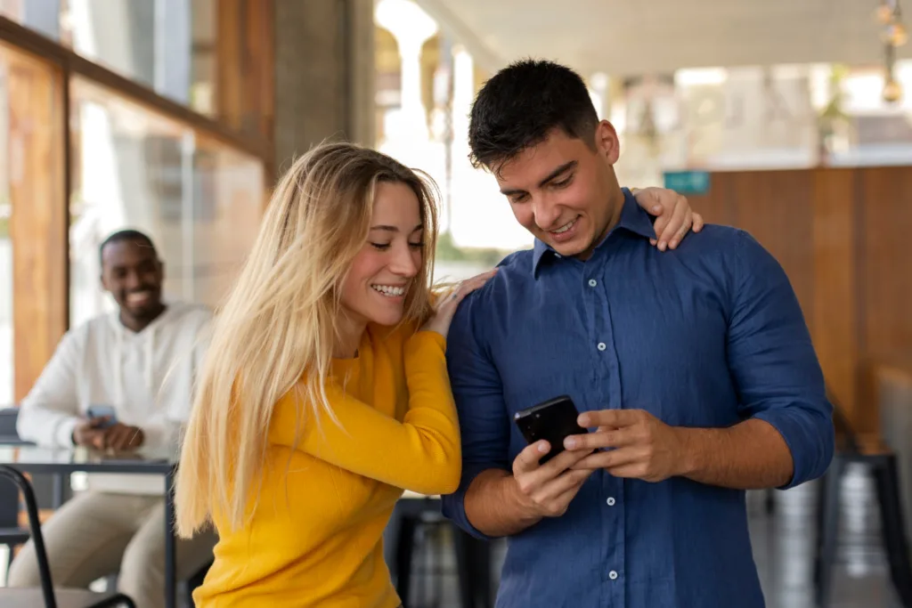 casal jovem feliz consultando um smartphone.