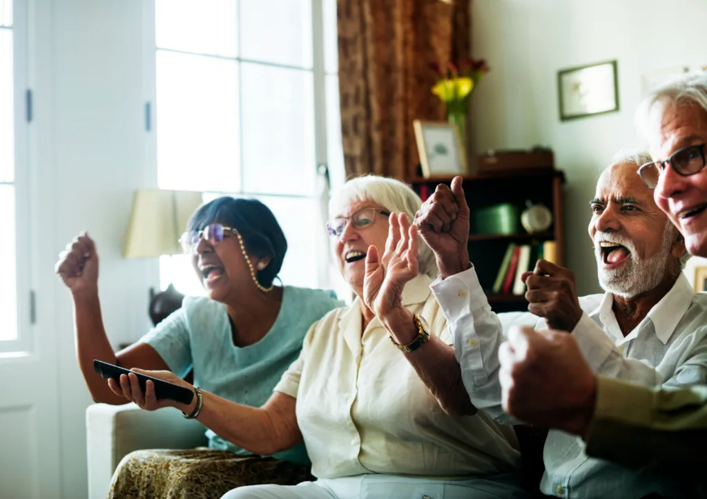 casais de idosos sentados felizes num sofa.