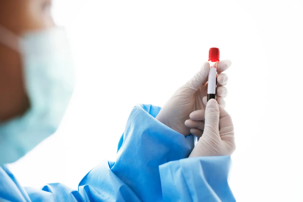 Cientista segurando um tubo com amostras de sangue.