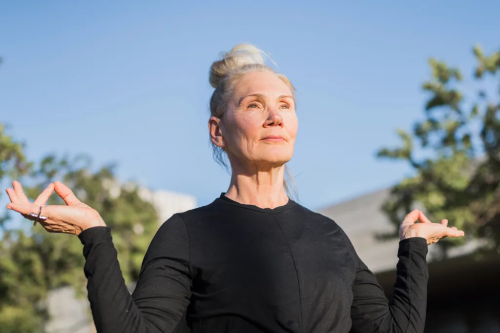mulher idosa em pose de yoga.