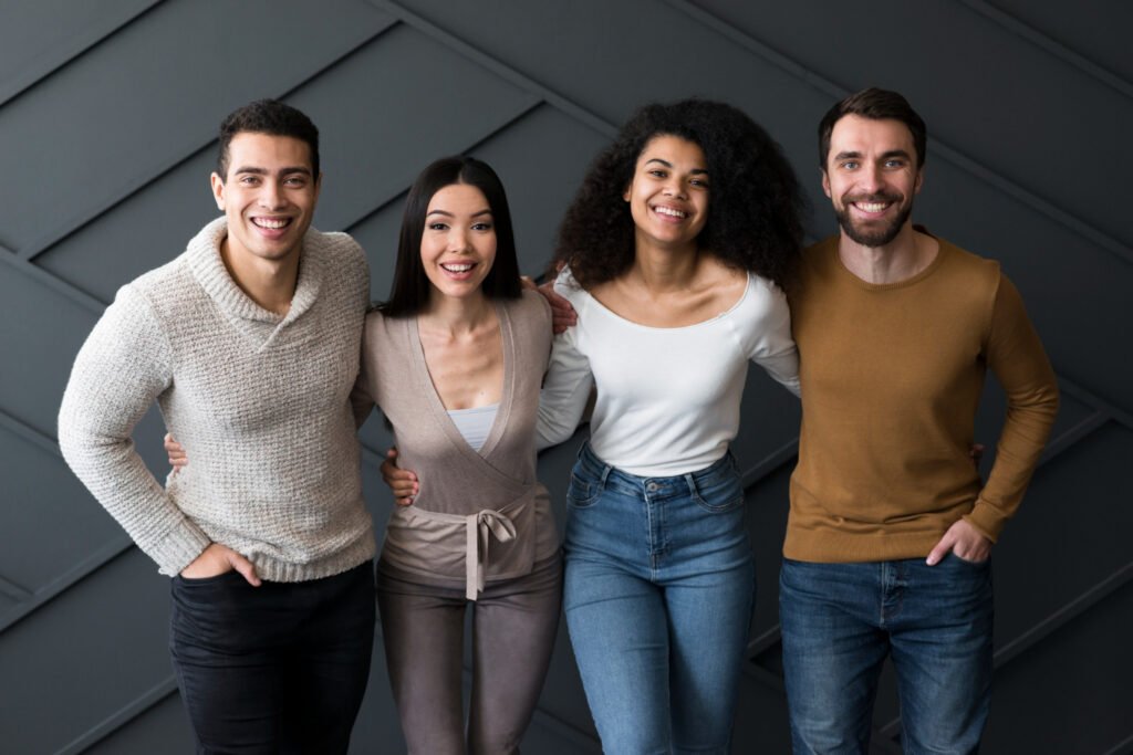 grupo de pessoas adultas jovens abraçadas lado a lado.