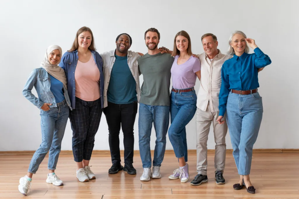 grupo de pessoas adultas jovens abraçadas lado a lado.