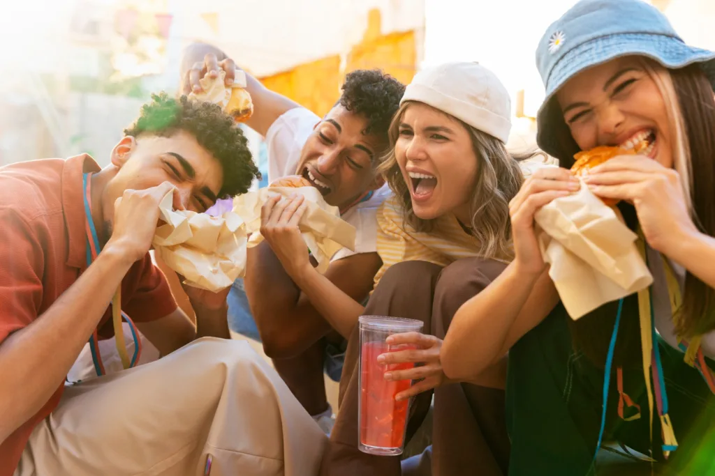 jovens felizes comendo fast food.