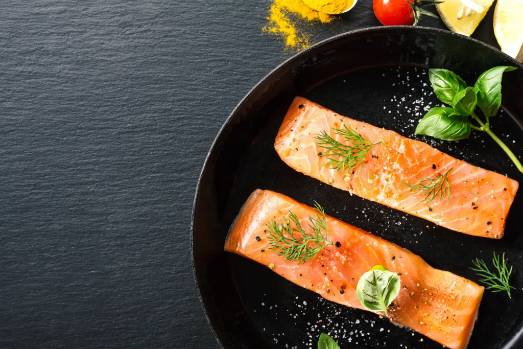 dois pedaços de salmão grelhado com ervas frescas.