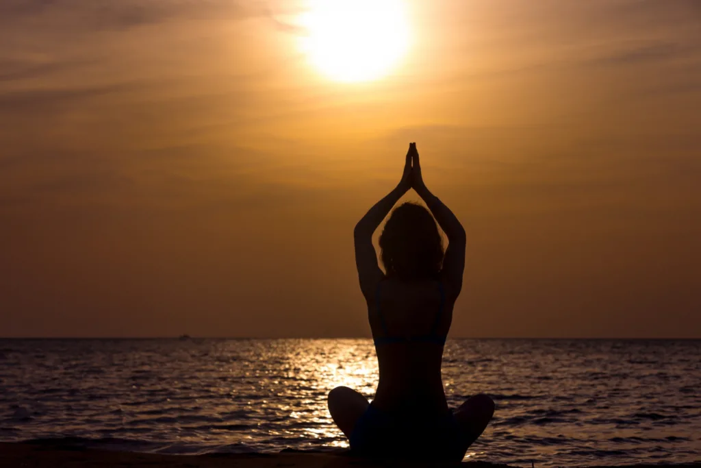 linda foto de uma pessoa meditando no crepúsculo.