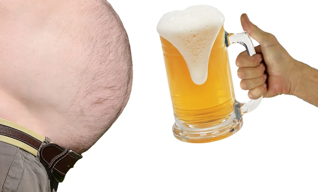 foto de uma barriga masculina com grande gordura abdominal ao lado de uma grande jarra de cerveja.