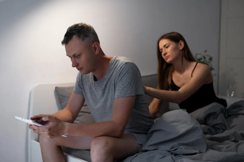 foto de um casal sentado na cama aparentado problema de relacionamento.