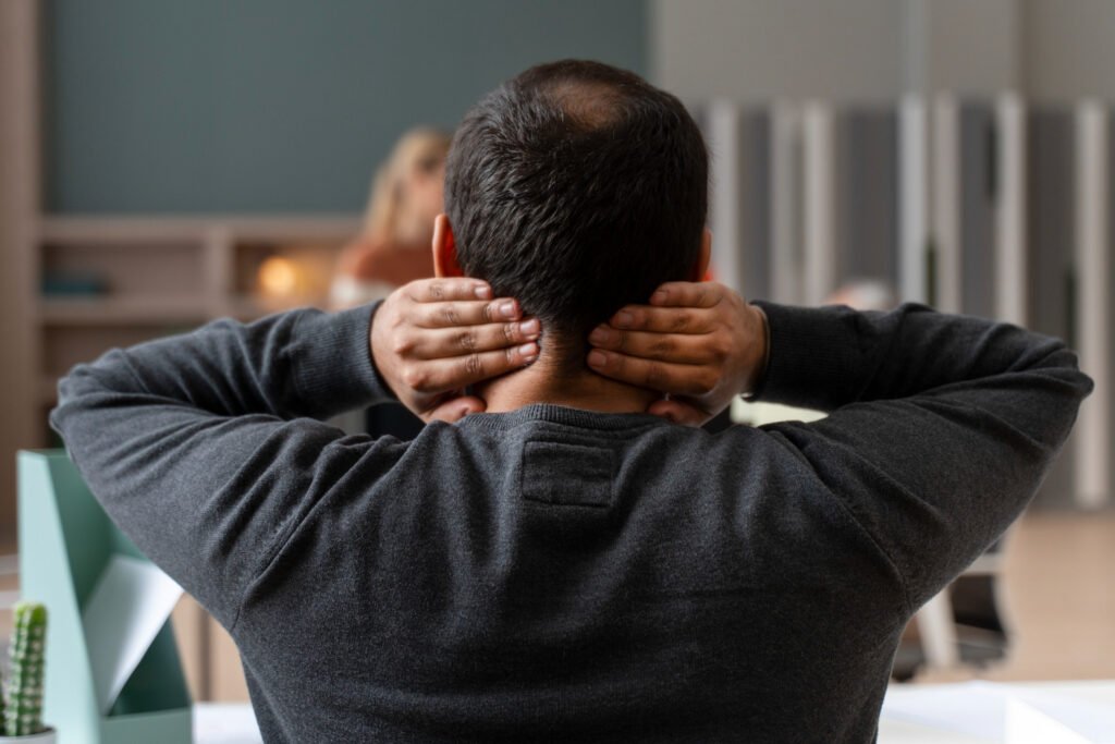 homem de costas com dores no pescoço.
