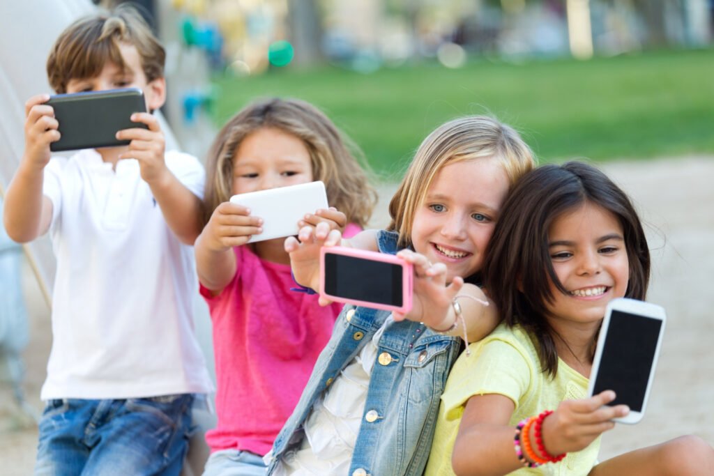 grupo de crianças fazendo selfie com smartphone.