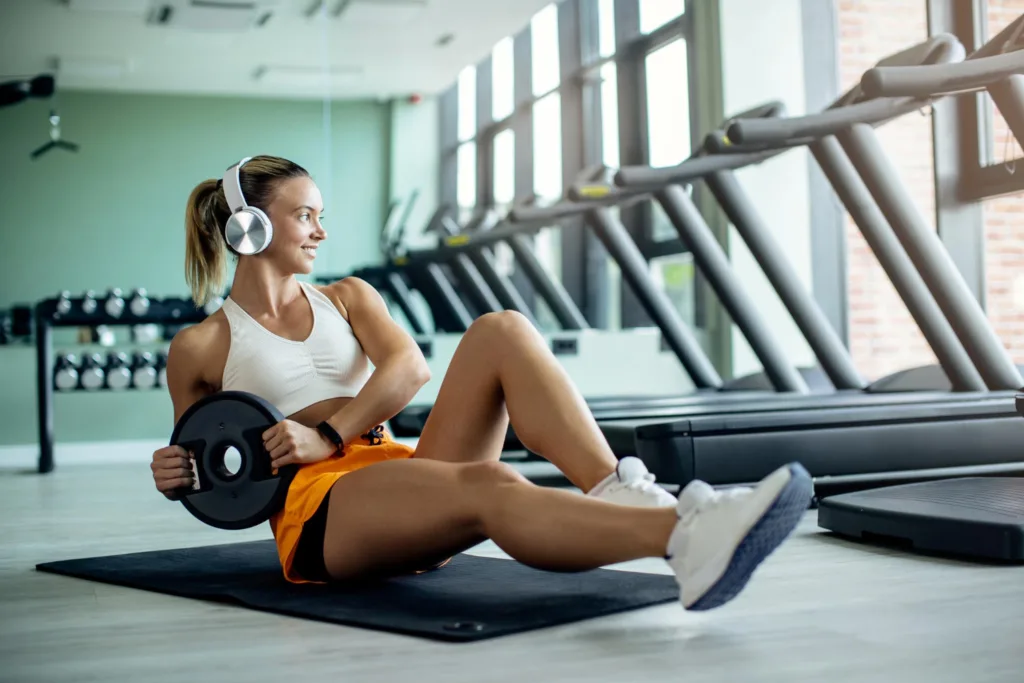 mulher jovem praticando exercícios de sola numa academia.