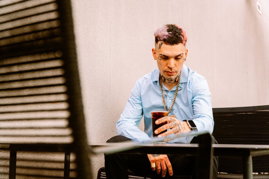 jovem em uma mesa de bar com uma bebida.