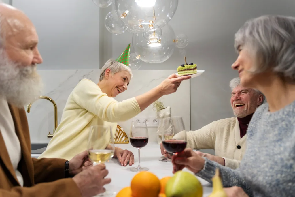 amigos da terceira idade comemorando em uma mesa.