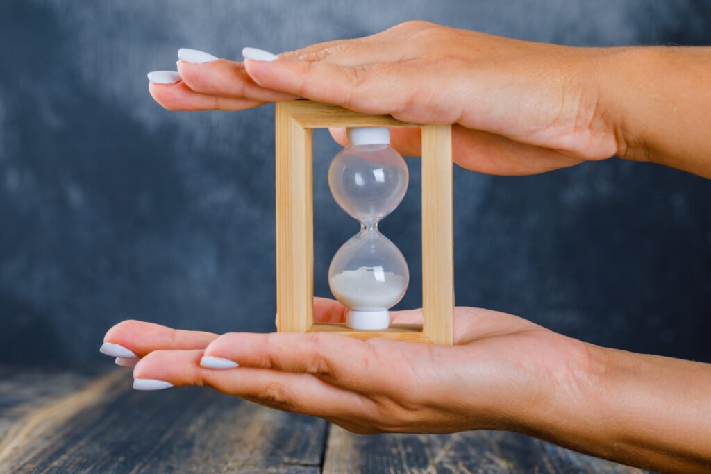 duas mãos segurando uma ampulheta.