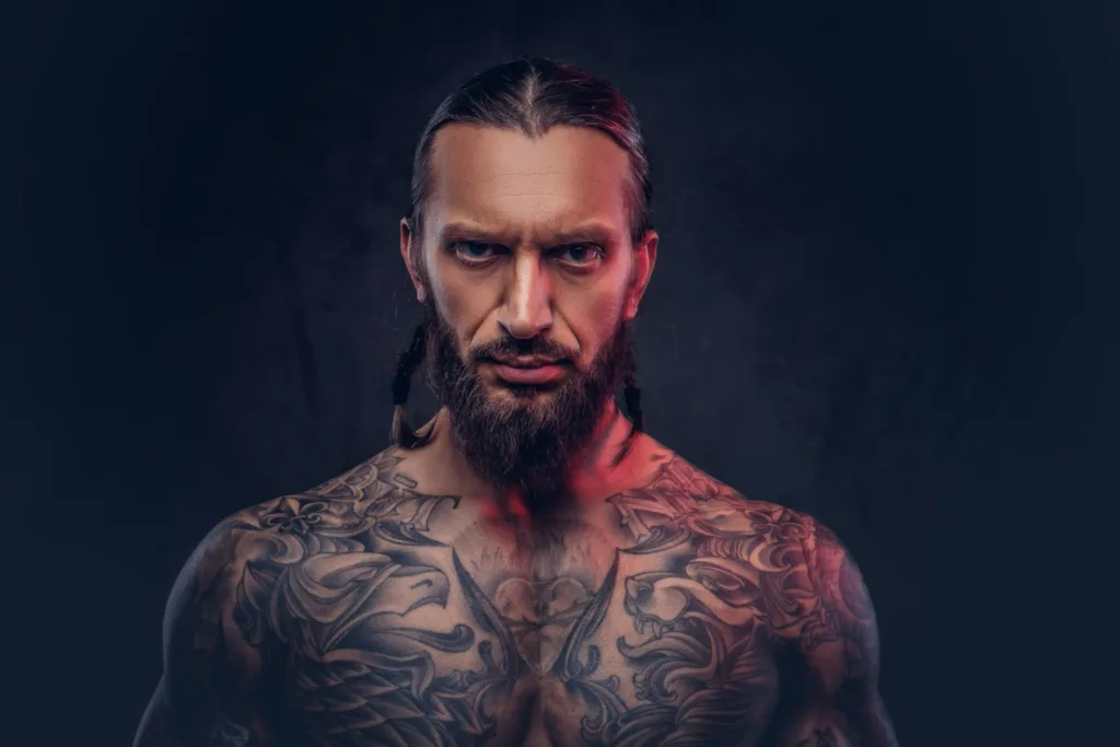 homem com barba, com o dorso todo tatuado.