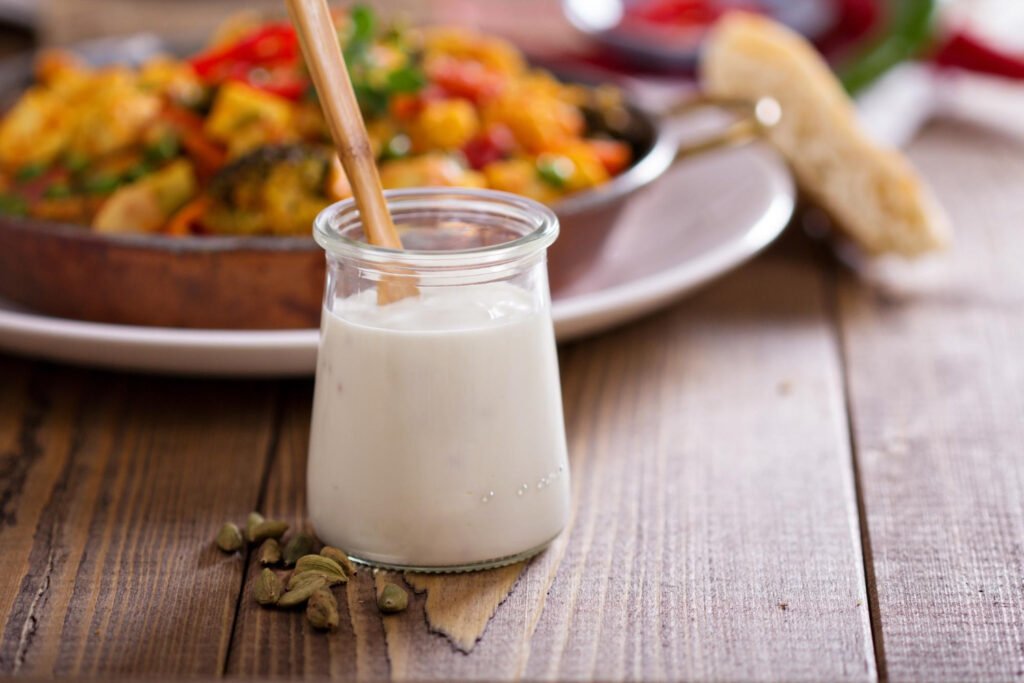 frasco de probiótico ao lado de um prato de salada.