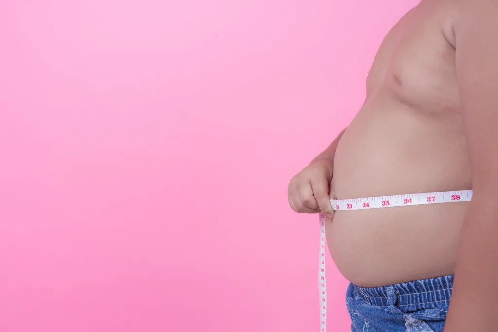 homem medindo sua grande barriga com uma fita métrica.