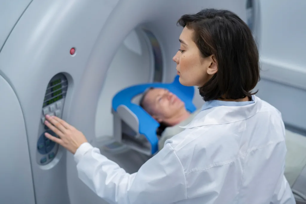 Técnica diagnosticando paciente numa ressonância magnética.
