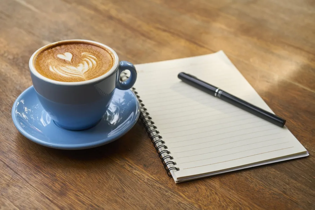 xícara de café e um caderno de notas.