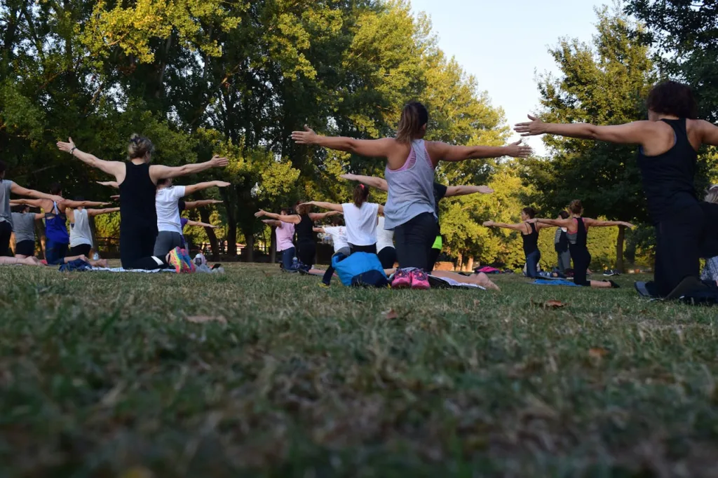 grupo de pessoas praticando yoga ao ar livre.