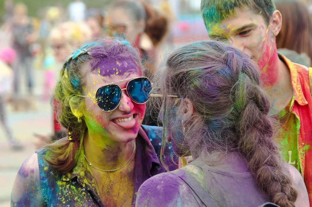 jovens festejando num ambiente com tintas coloridas.