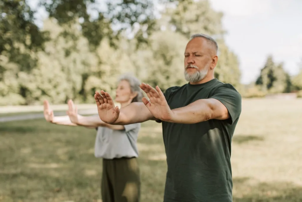 casal praticando tai chi ao ar livre.